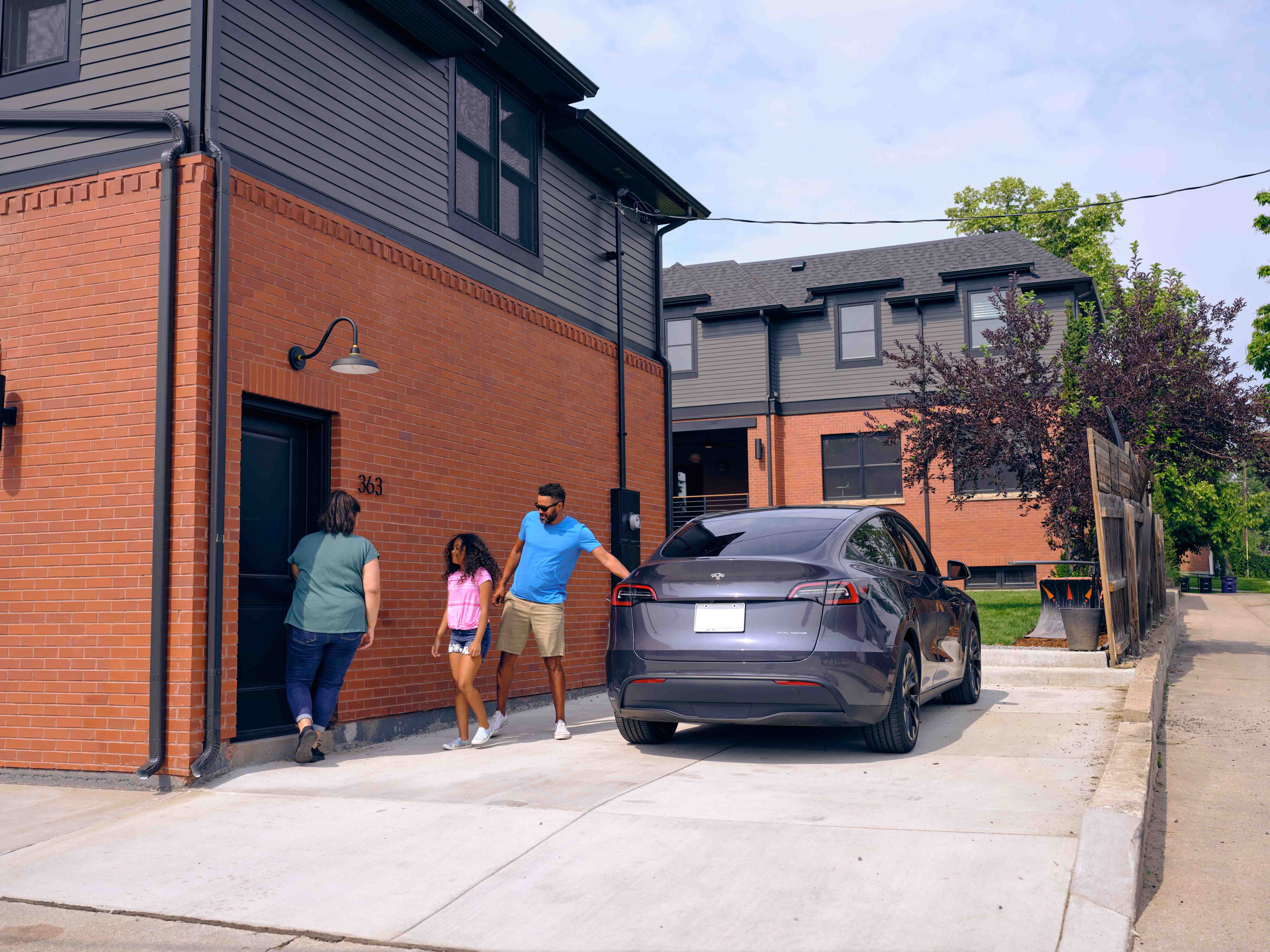 Family entering front door of brick townhome